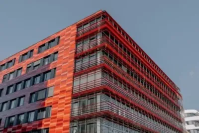 Wüstenrot Filiale Nähe: So findest du die nächste Beratungsstelle in deiner Umgebung 2 "Großes Gebäude mit roter Fassade und vielen Fenstern, Bürogebäude"