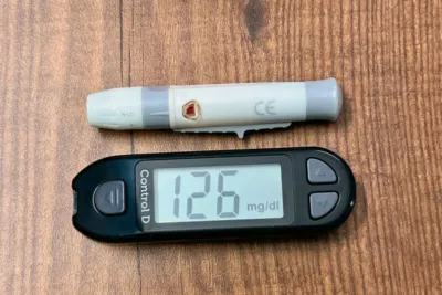Diabetes Blutwerte Kleines Blutbild: Was Dein kleines Blutbild wirklich über Zucker & Co verrät 4 "Blutzuckermessgerät und Teststreifen mit Blutprobe auf Holzoberfläche, Blutzuckerwert 126 mg/dl"