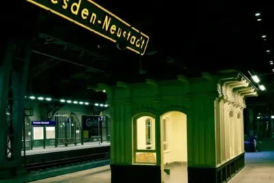 "Bahnhof Dresden-Neustadt, Sachsen, Straßenschild und Bahnhofshalle bei Nacht"
