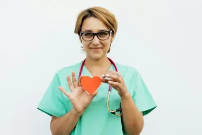 Hausarzt Check Up: Wann, wie oft und was wirklich zählt – Ihr kompletter Vorsorge-Guide 5 "Ärztin hält ein rotes Herz in der Hand, Vorsorgeuntersuchung, Gesundheitscheck"